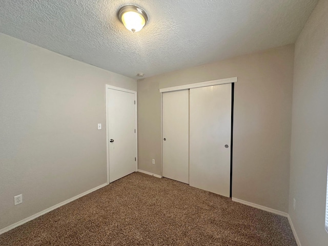 unfurnished bedroom featuring a textured ceiling, a closet, and carpet