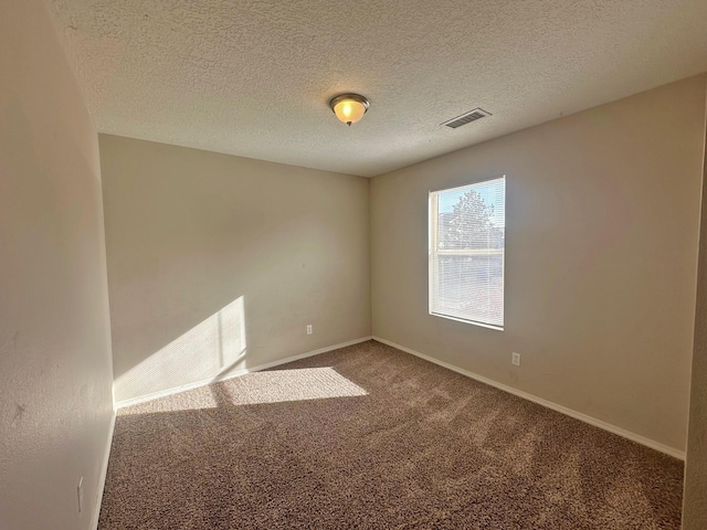 unfurnished room with a textured ceiling and carpet floors