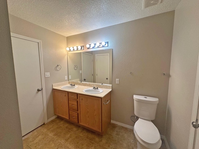 bathroom with toilet, a textured ceiling, and vanity