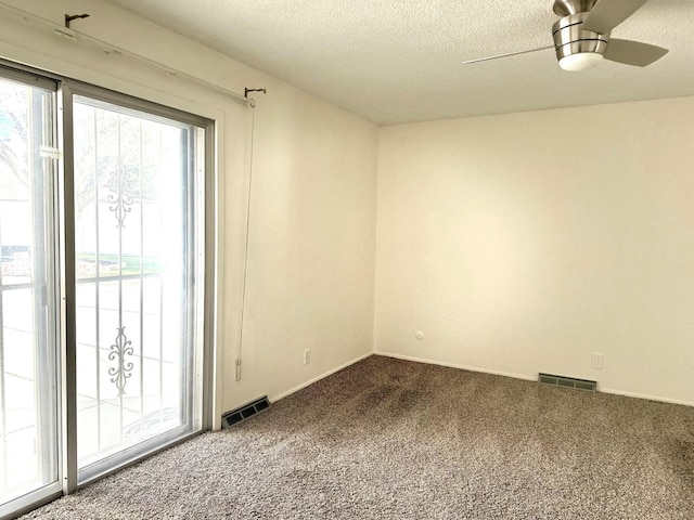 unfurnished room with carpet, ceiling fan, and a textured ceiling