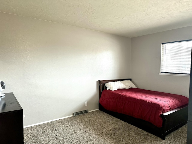 carpeted bedroom featuring a textured ceiling