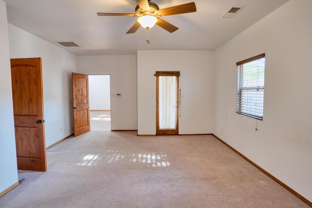 carpeted spare room with ceiling fan