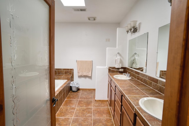 bathroom with tasteful backsplash, vanity, tile patterned flooring, and a relaxing tiled tub