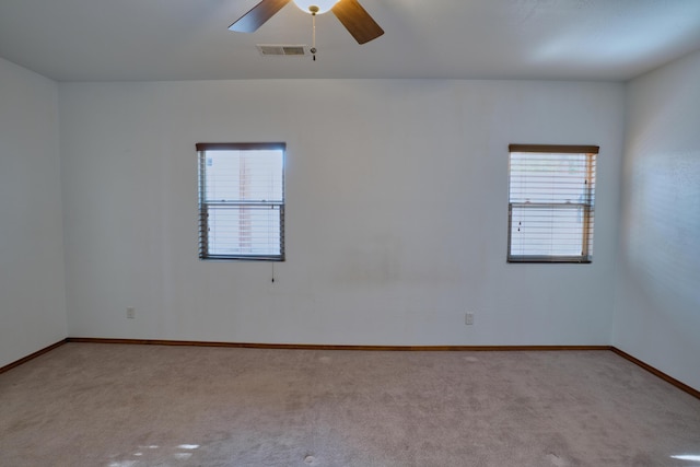 carpeted spare room featuring ceiling fan