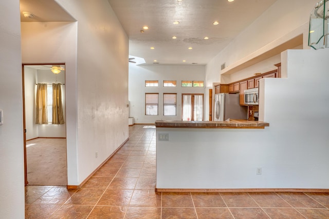 kitchen featuring stainless steel appliances, kitchen peninsula, and ceiling fan