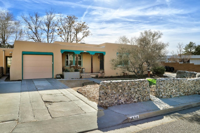 pueblo revival-style home featuring a garage