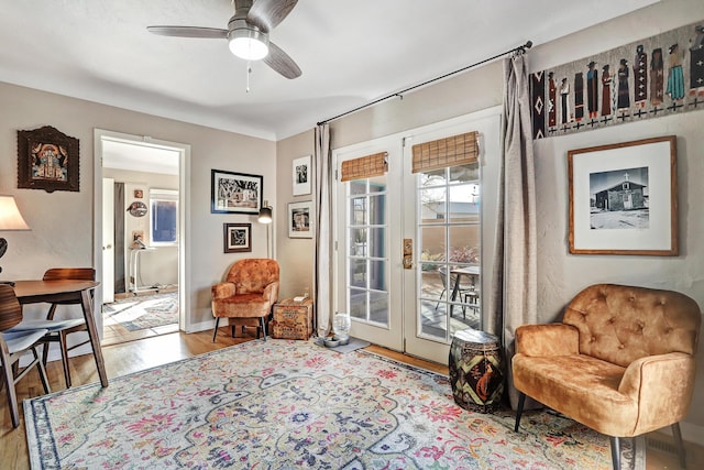 sitting room featuring ceiling fan, light wood-type flooring, and french doors