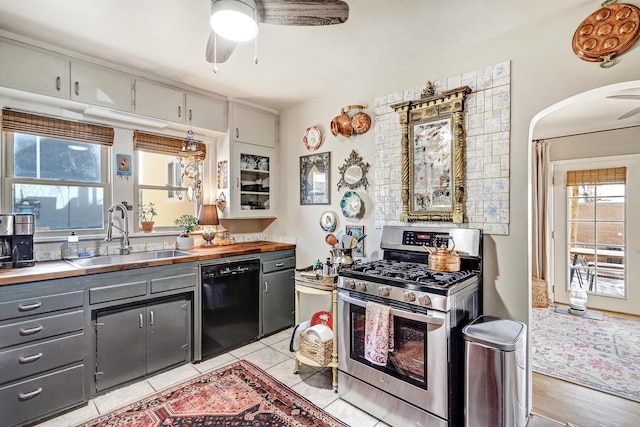 kitchen featuring gray cabinetry, stainless steel gas range, ceiling fan, sink, and dishwasher