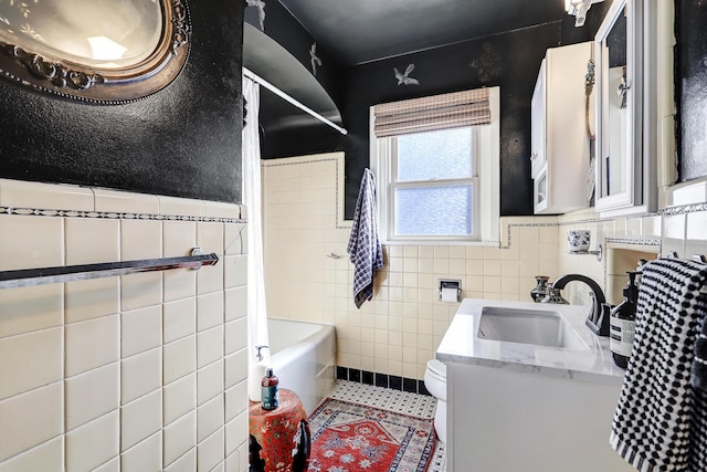 full bathroom featuring vanity, shower / bath combo with shower curtain, tile walls, tile patterned flooring, and toilet