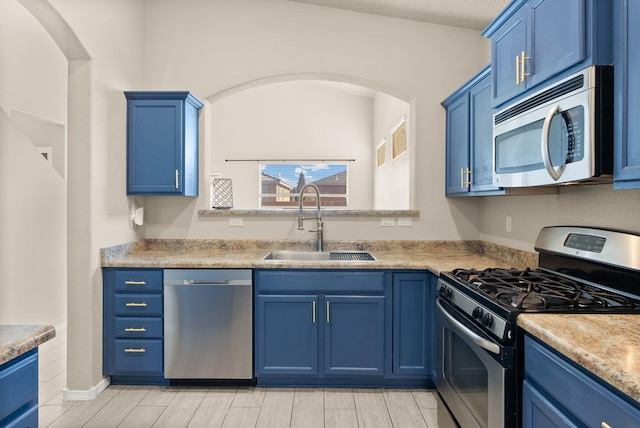 kitchen with stainless steel appliances, blue cabinets, and sink