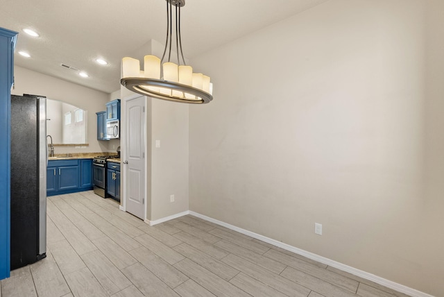 kitchen featuring sink, hanging light fixtures, light hardwood / wood-style flooring, blue cabinetry, and stainless steel appliances