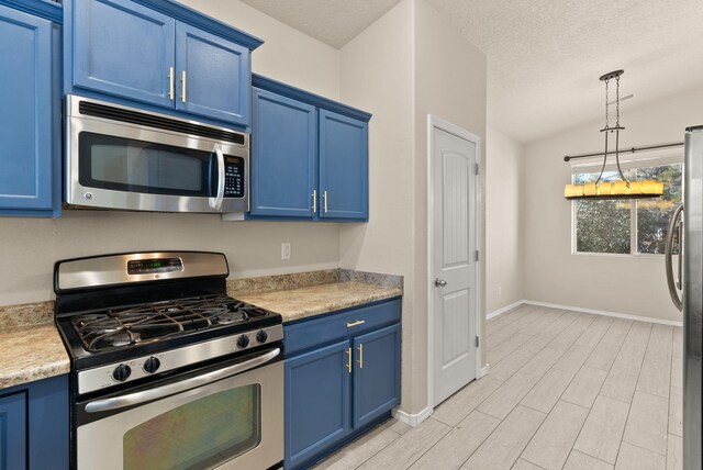 kitchen featuring blue cabinetry, appliances with stainless steel finishes, a textured ceiling, and hanging light fixtures