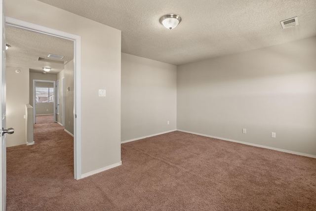 unfurnished room with carpet flooring and a textured ceiling