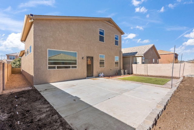 back of house featuring a lawn and a patio