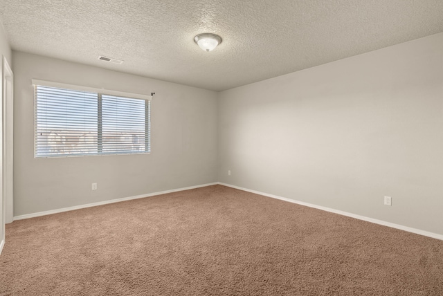 carpeted empty room with a textured ceiling