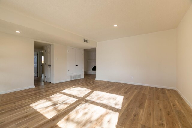 spare room with french doors, a textured ceiling, and light hardwood / wood-style flooring