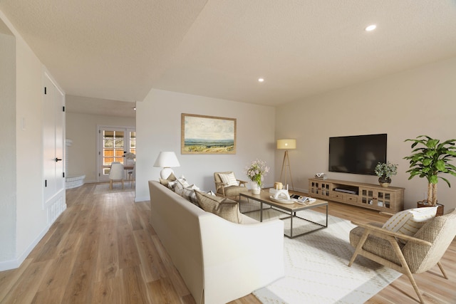 living room featuring light hardwood / wood-style floors and a textured ceiling