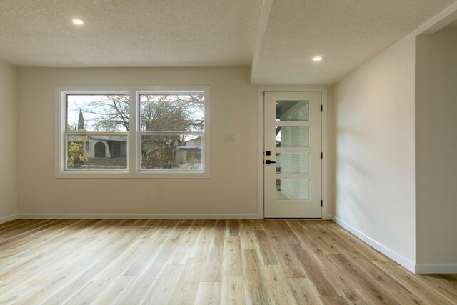 foyer with light hardwood / wood-style floors and a textured ceiling