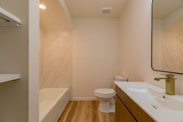 full bathroom with vanity, tub / shower combination, hardwood / wood-style floors, and toilet