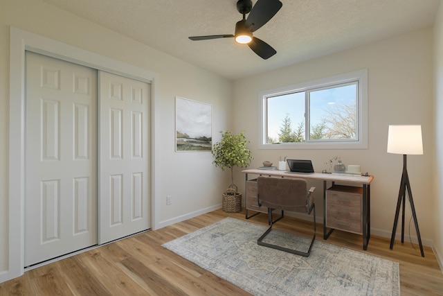 office space featuring a textured ceiling, ceiling fan, and light wood-type flooring