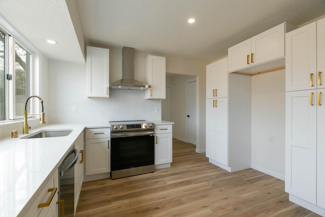 kitchen featuring stainless steel electric range oven, sink, white cabinets, and wall chimney exhaust hood