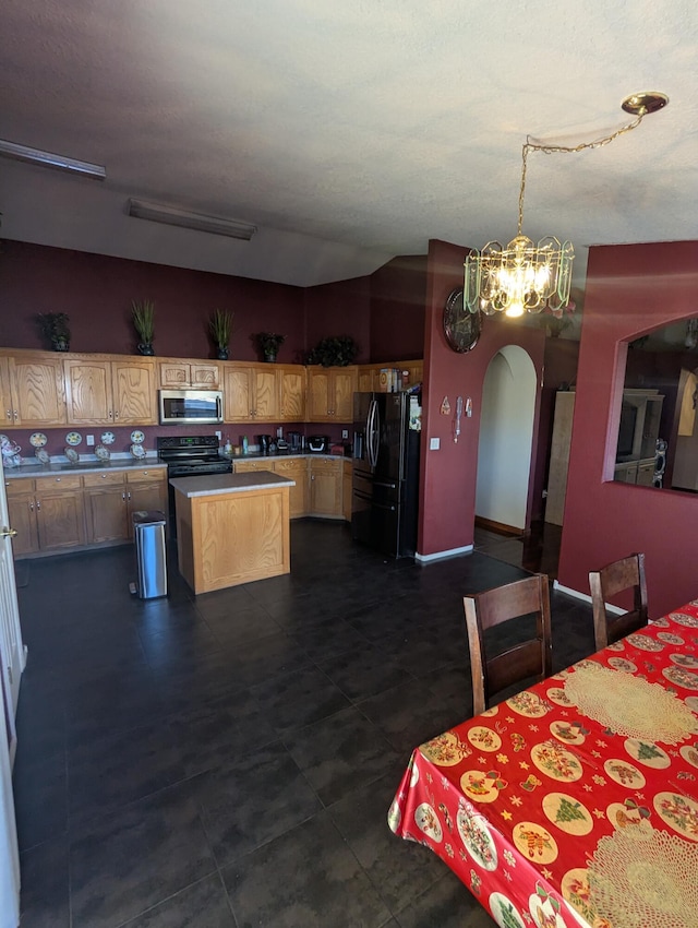 kitchen featuring pendant lighting, black refrigerator with ice dispenser, range with electric cooktop, and a center island