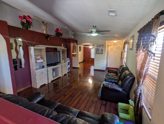 living room featuring ceiling fan, lofted ceiling, dark hardwood / wood-style floors, and a textured ceiling