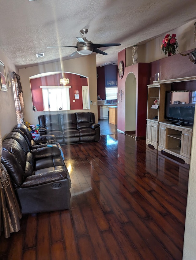 living room with hardwood / wood-style flooring, ceiling fan, and a textured ceiling