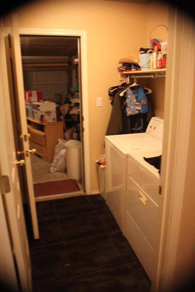 laundry area featuring dark tile patterned flooring and washing machine and clothes dryer