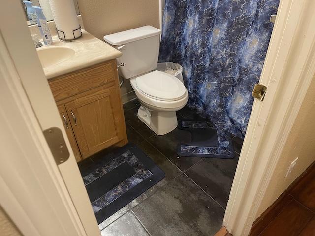 bathroom with tile patterned flooring, vanity, and toilet