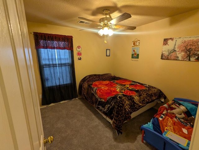 bedroom with a textured ceiling, ceiling fan, and carpet