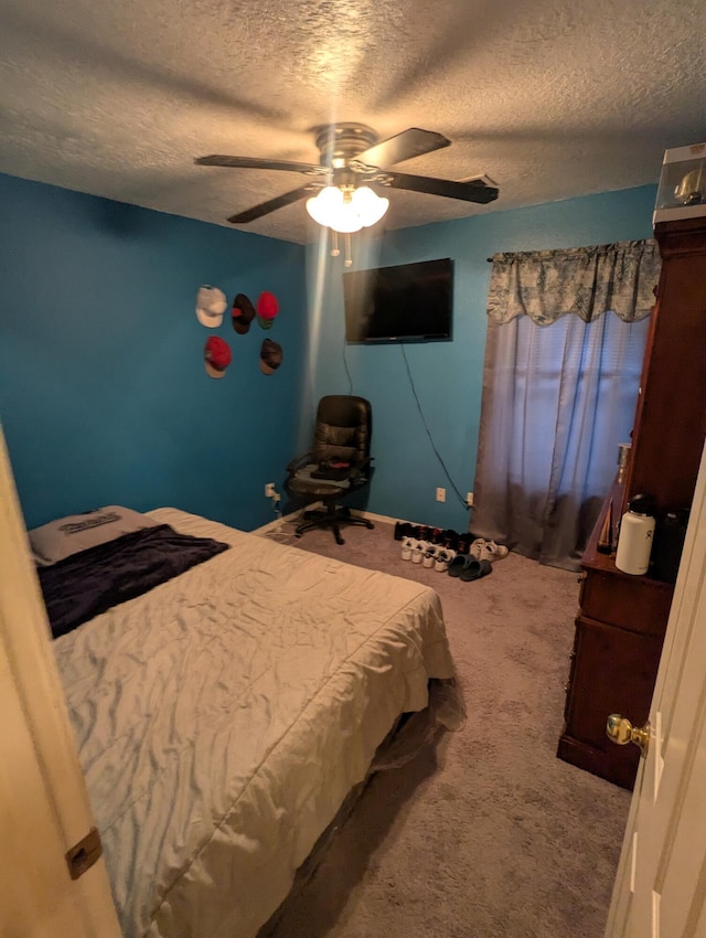 bedroom with a textured ceiling, ceiling fan, and carpet flooring