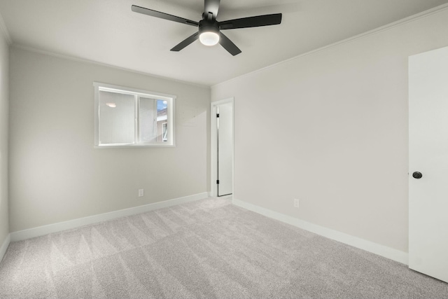 empty room featuring carpet floors, ceiling fan, and ornamental molding