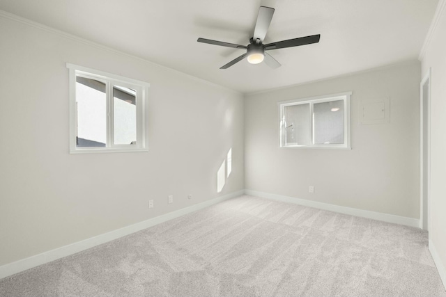 empty room with light colored carpet, ceiling fan, and crown molding