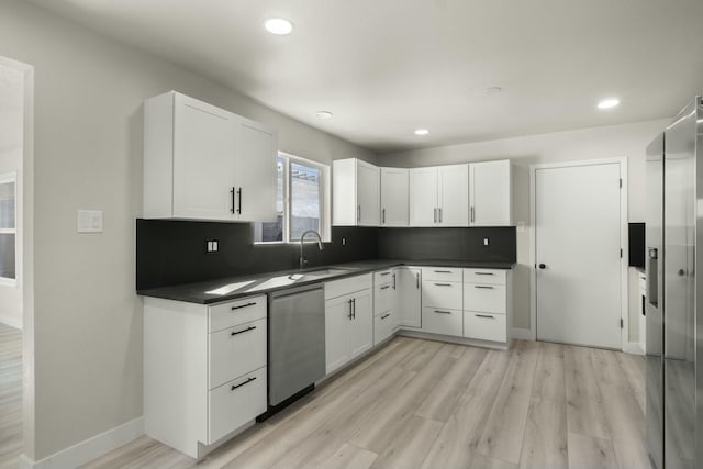 kitchen with dishwasher, light hardwood / wood-style flooring, backsplash, white cabinetry, and sink