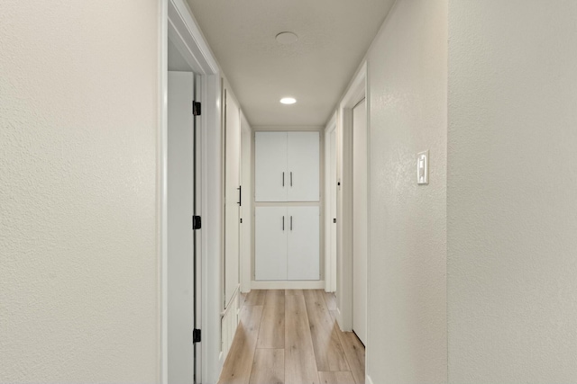 corridor with light hardwood / wood-style flooring