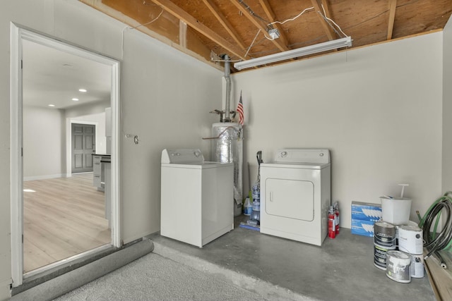 washroom with washer and clothes dryer and water heater