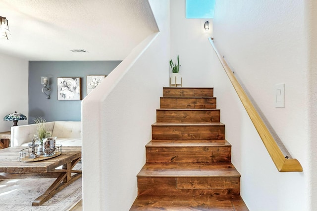 staircase with a textured ceiling