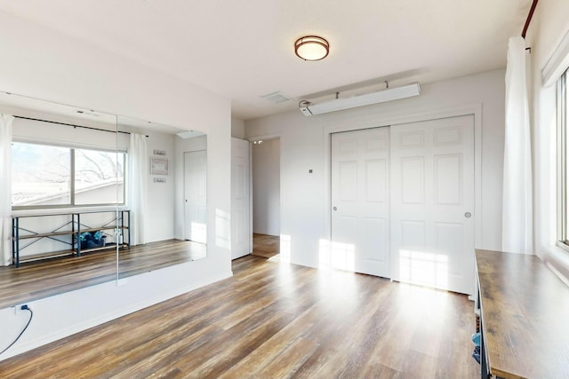 unfurnished bedroom with dark hardwood / wood-style flooring and a closet