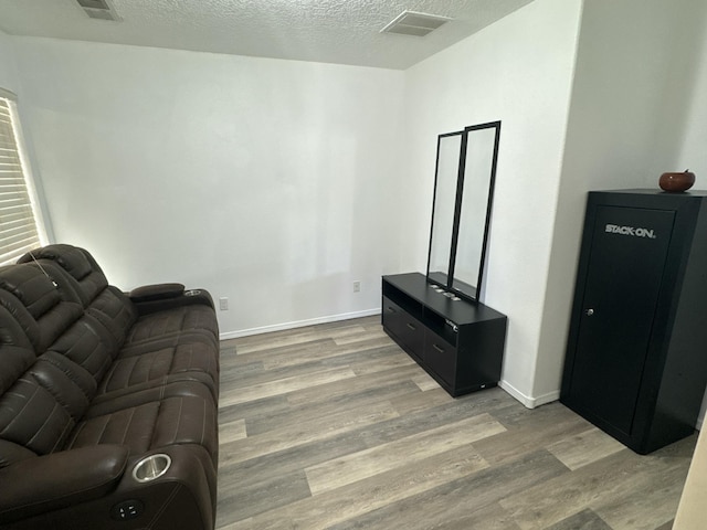 living room with a textured ceiling and light hardwood / wood-style flooring