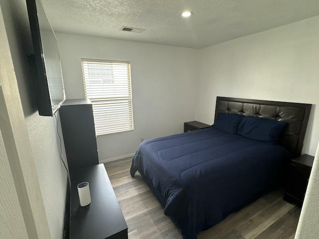 bedroom featuring hardwood / wood-style flooring and a textured ceiling