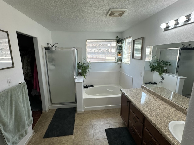 bathroom with tile patterned flooring, vanity, a textured ceiling, and independent shower and bath