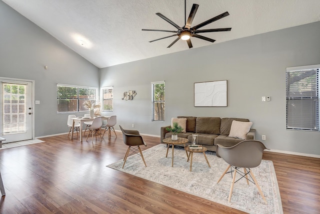 living room featuring a textured ceiling, ceiling fan, dark wood-type flooring, and high vaulted ceiling