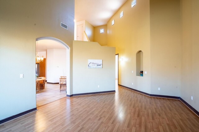 empty room with wood-type flooring and a high ceiling