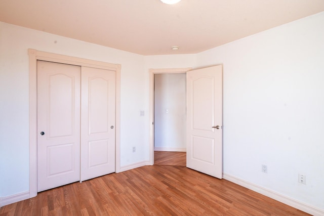 unfurnished bedroom with hardwood / wood-style floors and a closet