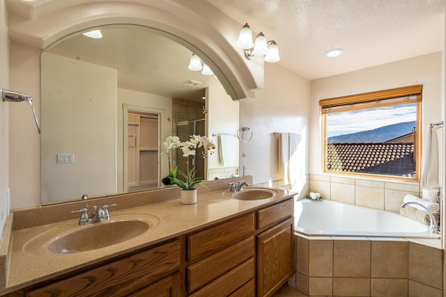 bathroom featuring tiled bath and vanity