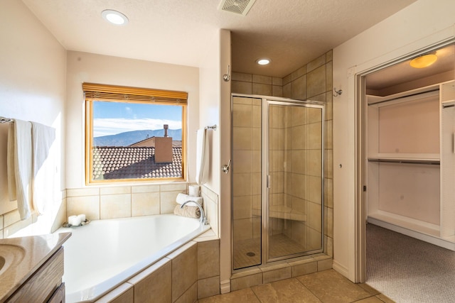 bathroom featuring tile patterned flooring, a mountain view, plus walk in shower, and vanity