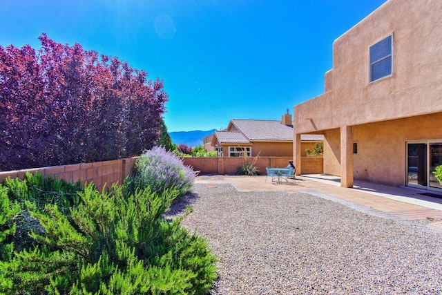 view of yard featuring a mountain view and a patio