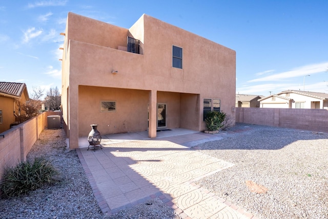 back of property with central air condition unit and a patio