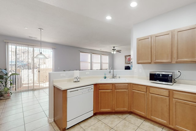 kitchen with light tile patterned flooring, decorative light fixtures, sink, white dishwasher, and kitchen peninsula